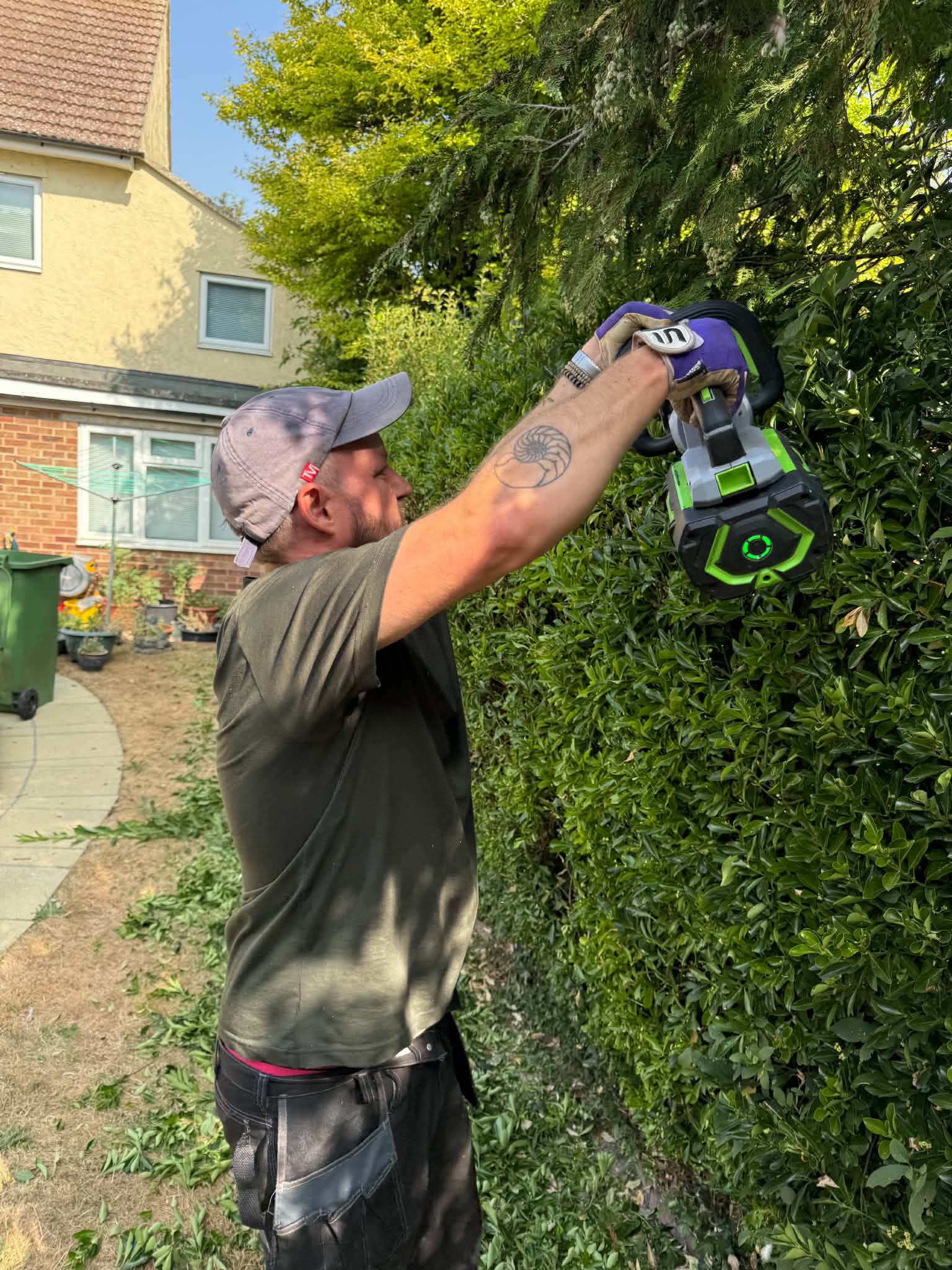 Good Garden Folk carrying out hedge trimming in Ely with a battery-powered trimmer